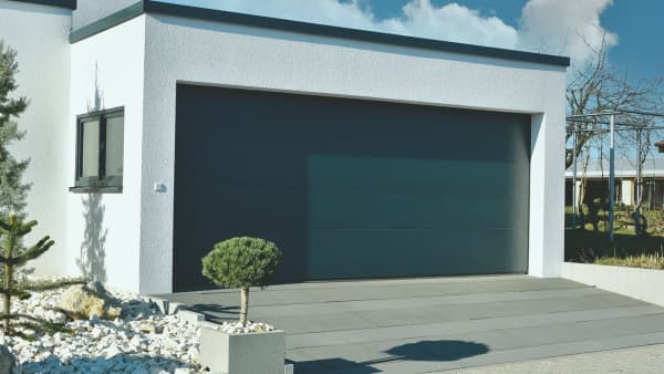 Garage mit breitem Garagentor und Fenster angebaut ans Wohnhaus