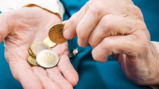 ältere Hände mit Münzen