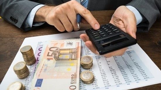 Ein Mann im Anzug berechnet die Beträge und zählt das Geld.
