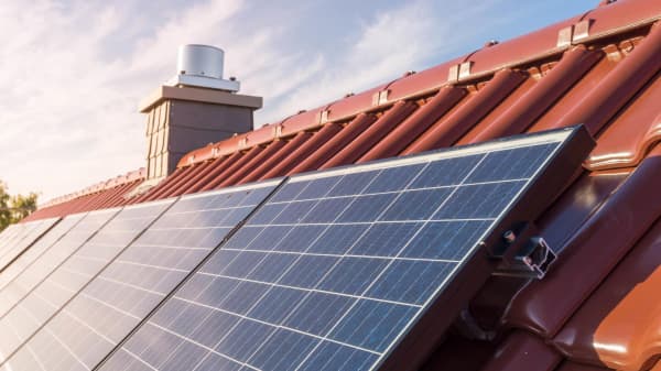 Photovoltaikmodule auf einem Schrägdach, das mit roten Ziegeln gedeckt ist