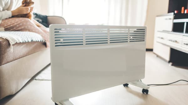 Bewegliche weiße Elektroheizung auf rollen im Wohnzimmer