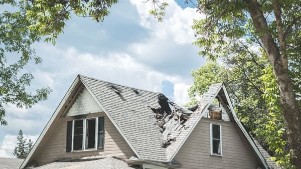 Haus mit schweren Sturmschäden braucht dringend eine Dachreparatur von Aroundhome