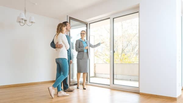Makler besichtigt mit Pärchen ein Haus