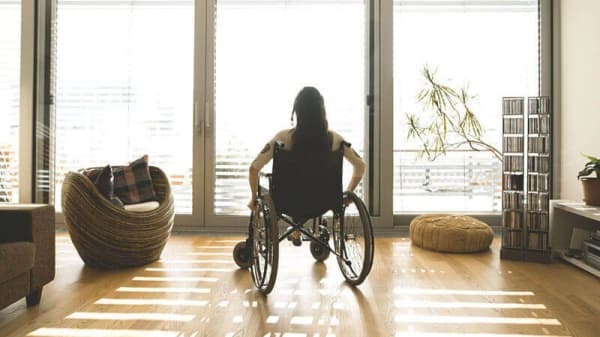 Frau in Rollstuhl im Wohnzimmer