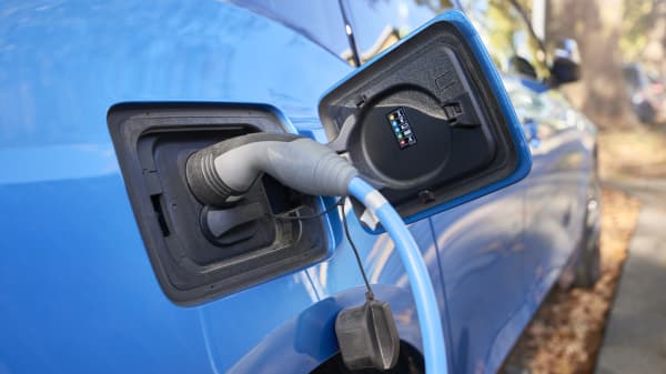 Nahaufnahme eines blauen E-Autos, das gerade geladen wird