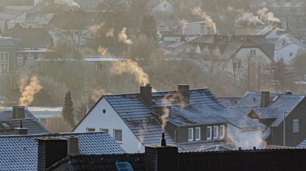 Wohnhäuser mit qualmenden Schornsteinen im Winter