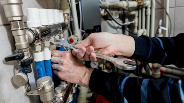 Ansicht der Hände eines Handwerkers, der an einer Heizung arbeitet