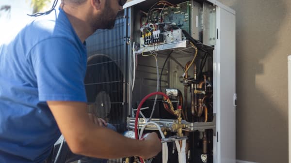 Handwerker arbeitet an der Elektrik einer Wärmepumpe