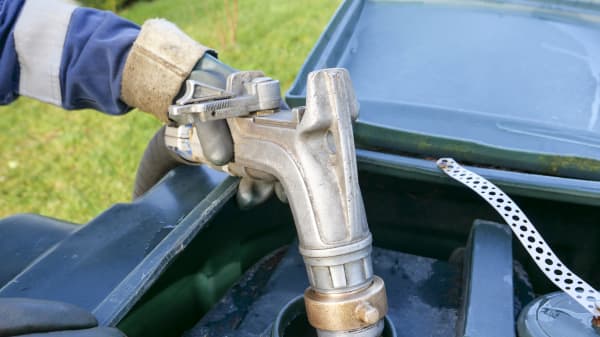 Heizöltank wird von einer Person mit Arbeitshandschuhen betankt