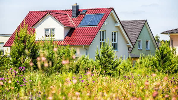 Moderne sanierte Einfamilienhäuser mit grüner Wiese im Vordergrund