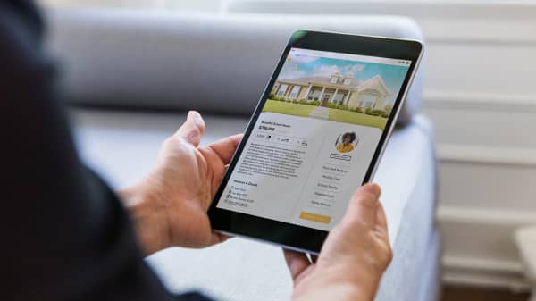 Person sieht sich das Inserat einer Immobilie auf einem Tablet an