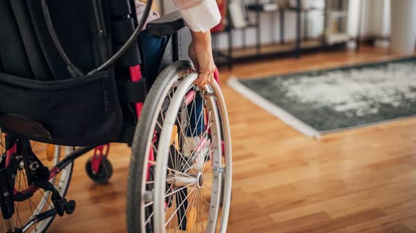 Nahaufnahme einer Rollstuhlfahrerin in ihrem Wohnzimmer zu Hause