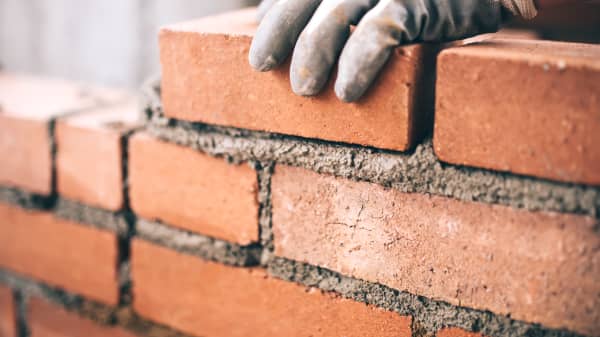 Nahaufnahme der Hand eines Maurers bei der Arbeit