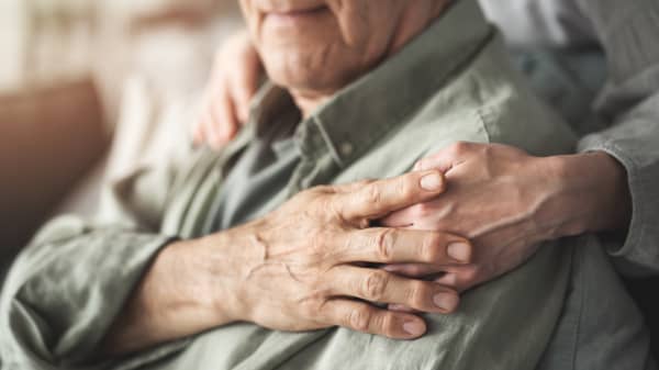 Hände einer Seniorin auf den Schultern eines Seniors