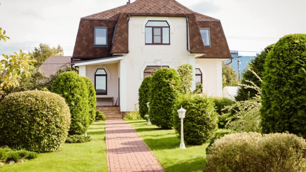 Freistehendes, älteres Einfamilienhaus mit brauner Dacheindeckung in gepflegtem Garten
