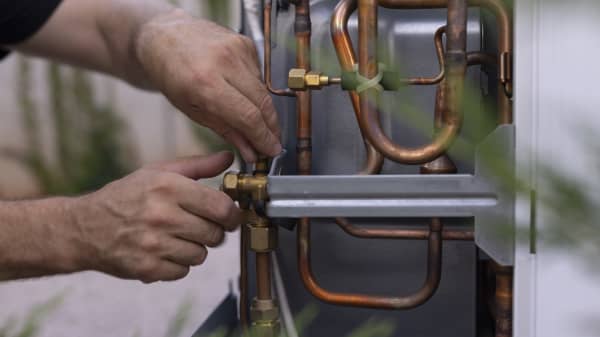 Installateur arbeitet an einer Wärmepumpe