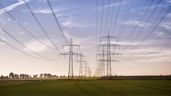 Strommasten in zwei Reihen bei Sonnenaufgang