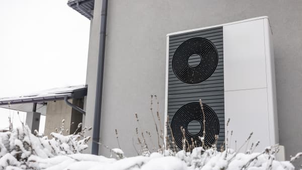 Luft-Wärmepumpen an Fassade eines Wohngebäudes im Schnee