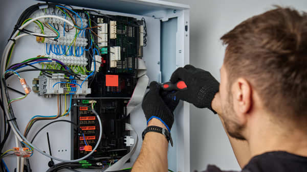 Monteur arbeitet an der Elektronik einer Wärmepumpe
