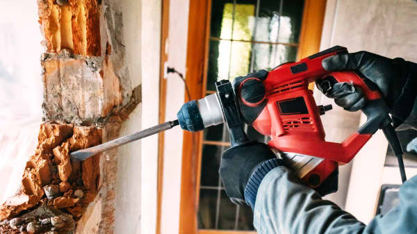 Arbeiter führt einen Wanddurchbruch durch