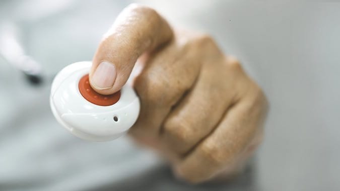 Hand drückt auf Notruf-Knopf