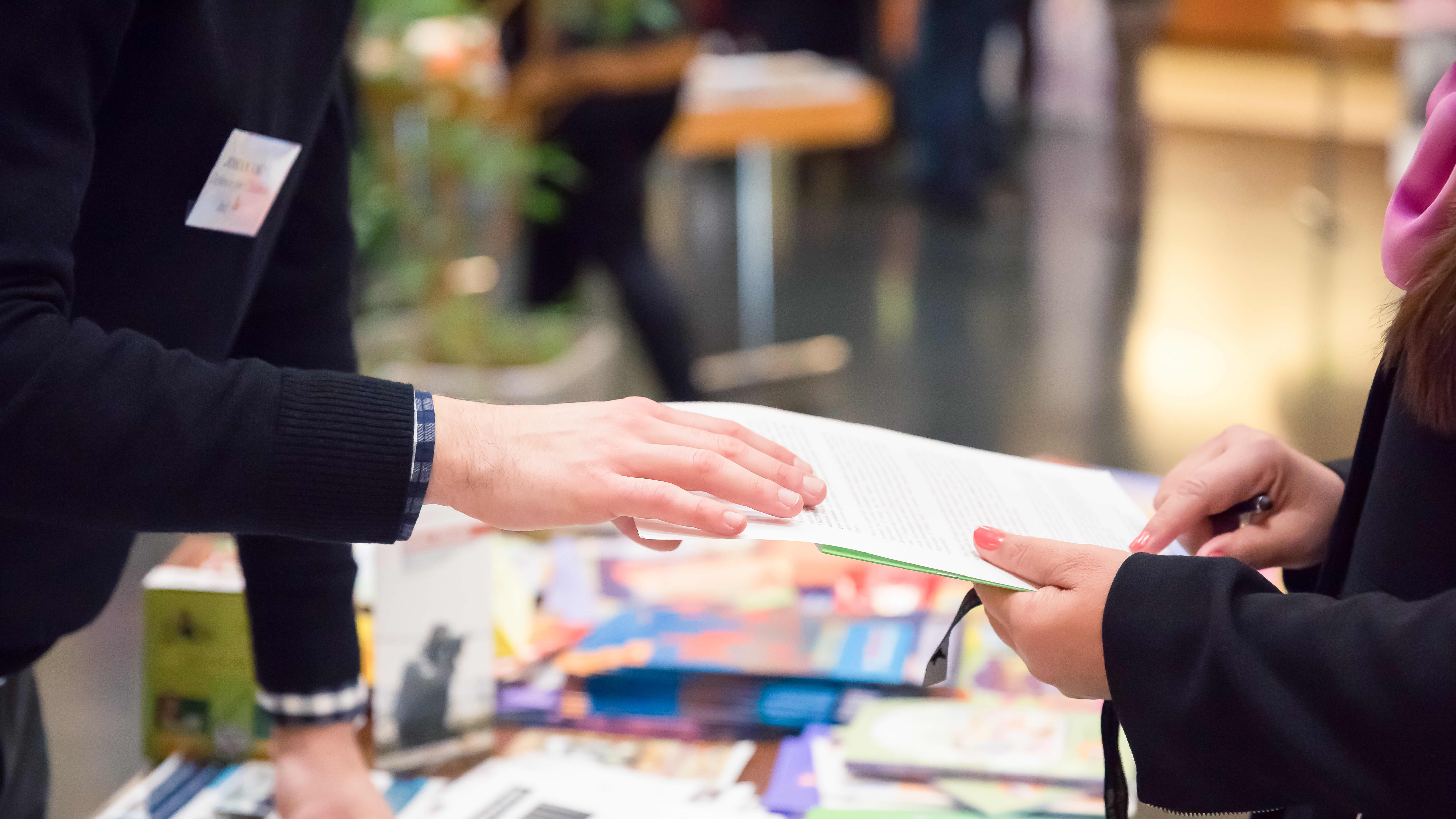 Nahaufnahme zweier Personen an einem Stand auf einer Messe