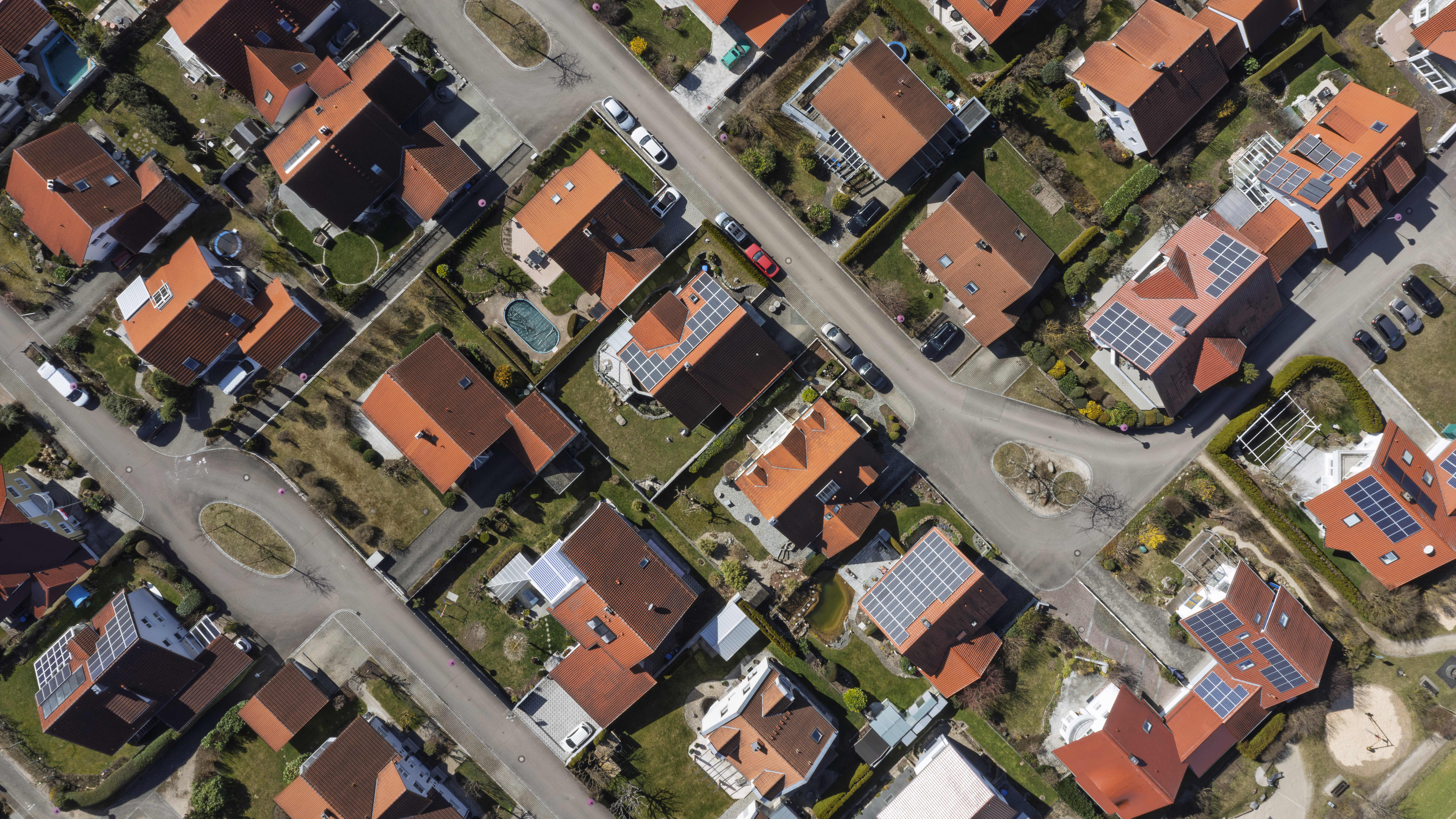 Luftaufnahme eines Wohngebiets mit Häusern, von denen einige mit Solaranlagen ausgestattet sind