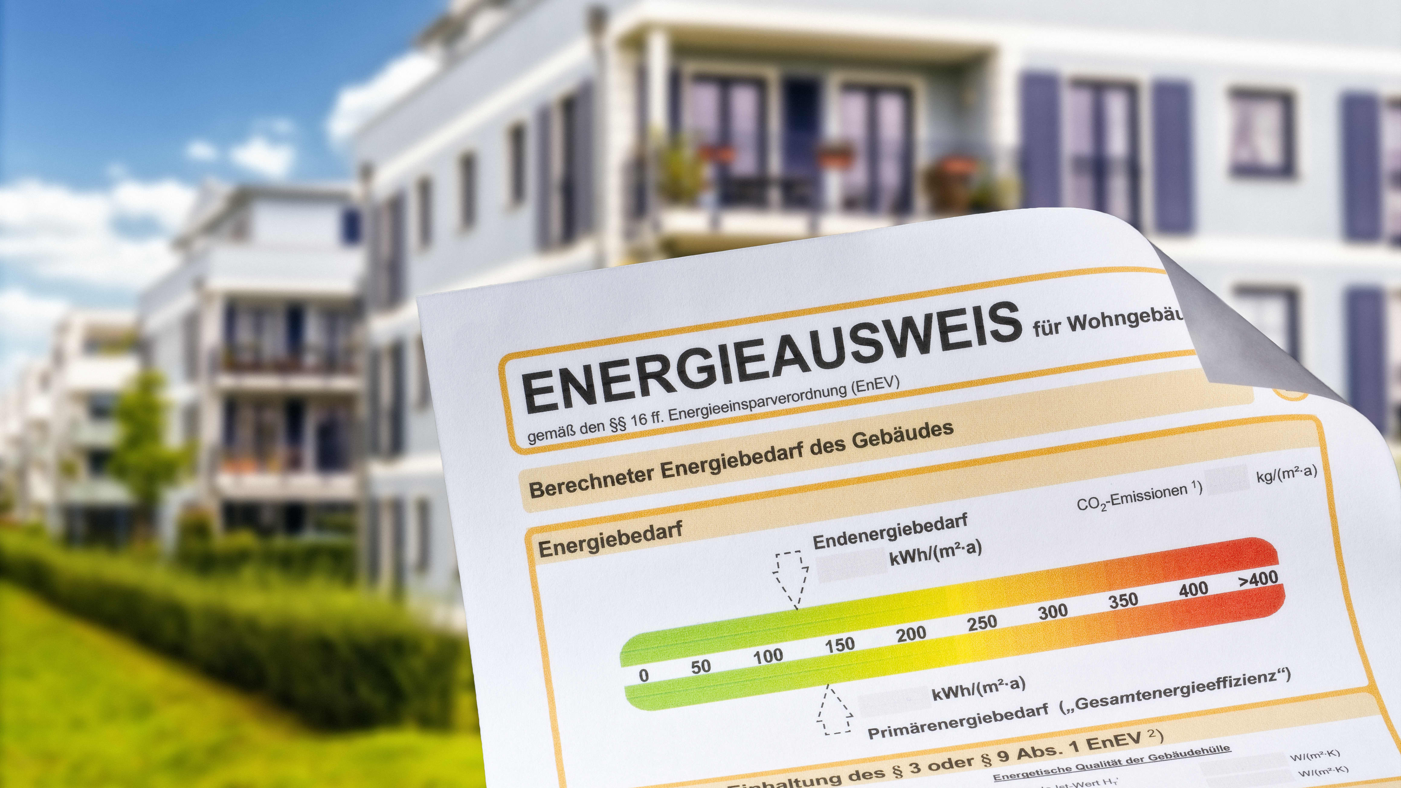 Energieausweis mit modernem Mehrfamilienhaus im Hintergrund
