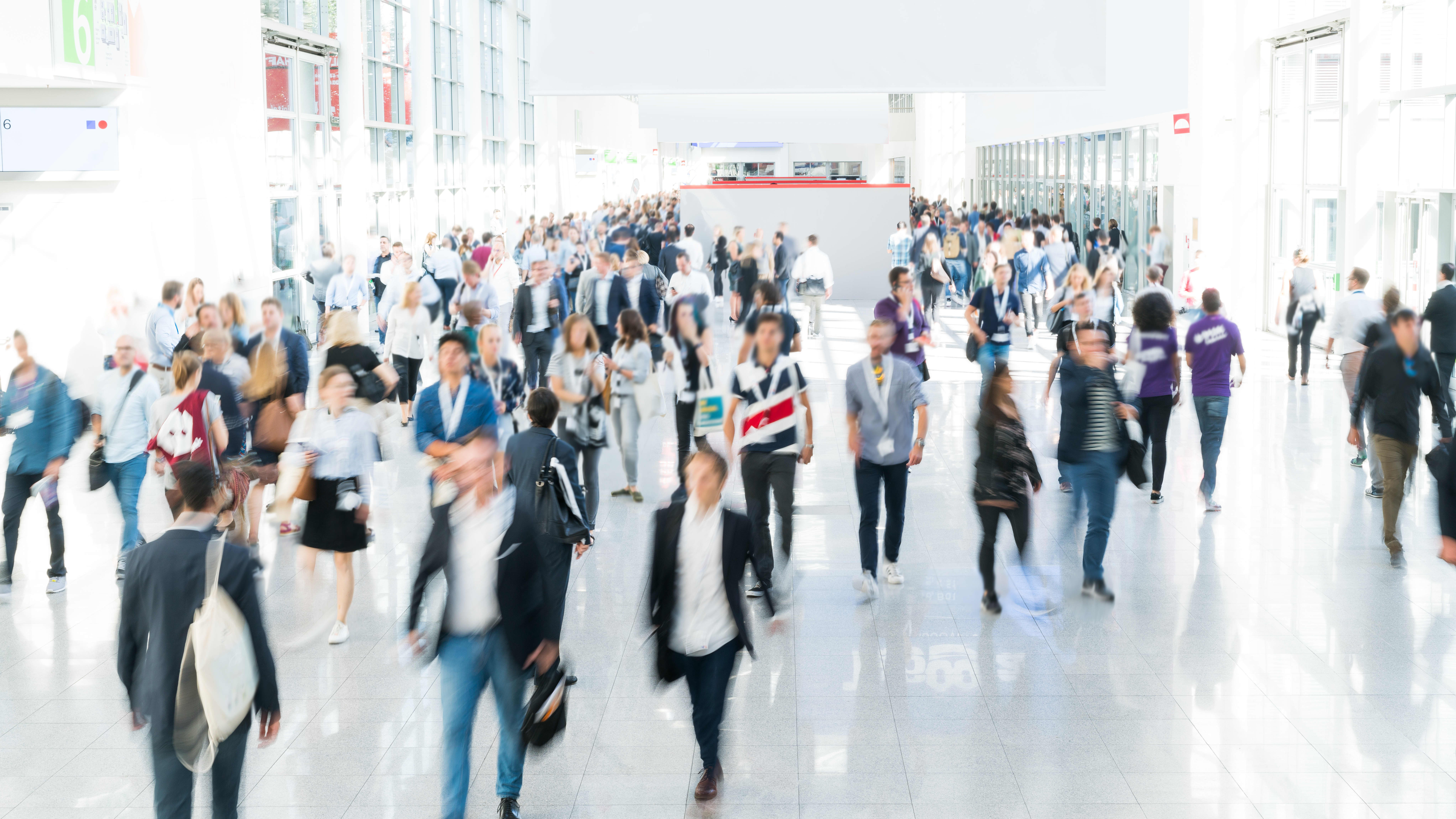 Verschwommene Menschen in einer Veranstaltungshalle auf einer Messe