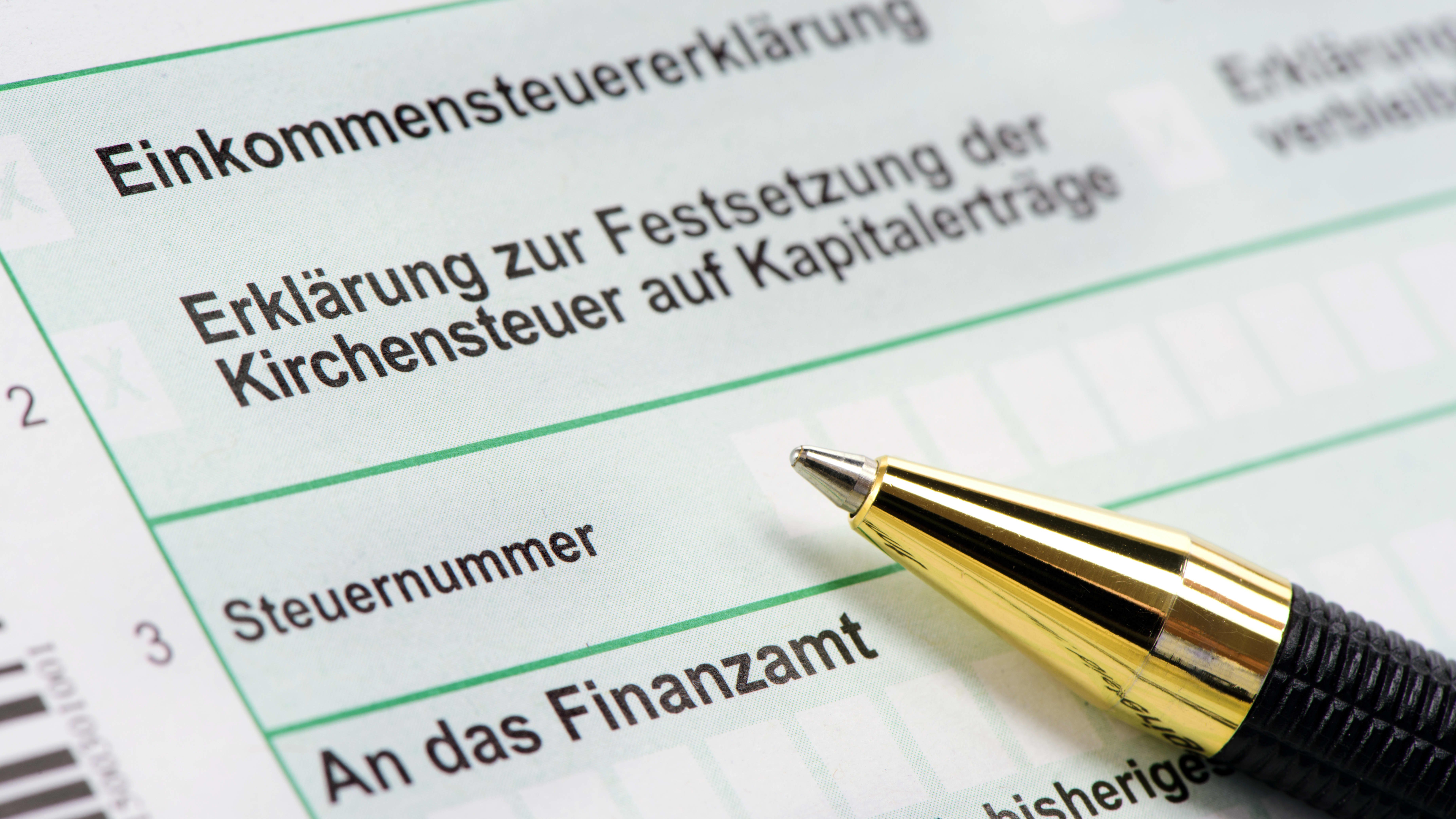 Nahaufnahme einer deutschen Einkommensteuererklärung, auf dem Formular liegt ein Kugelschreiber