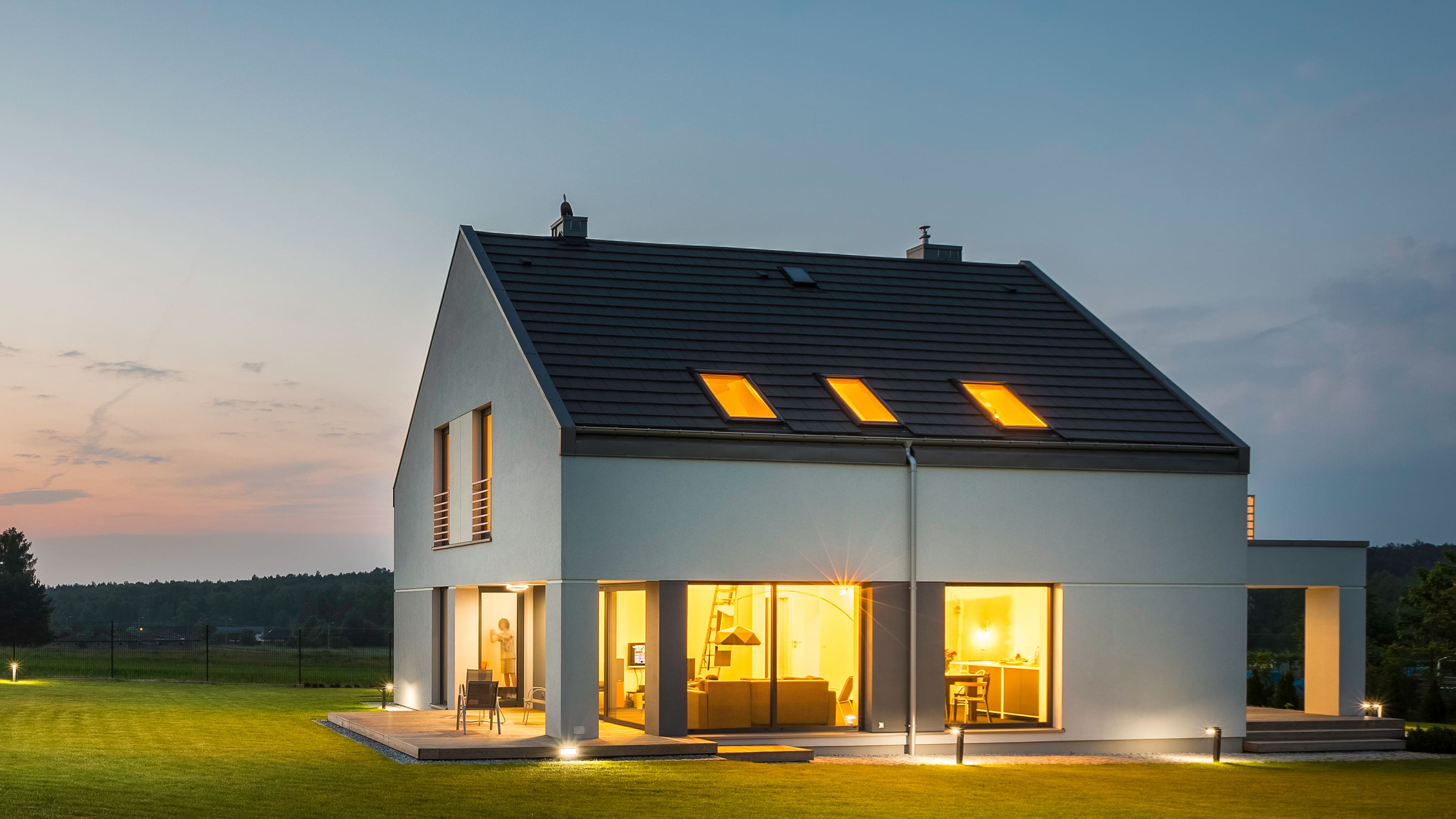 erleuchtes Einfamilienhaus bei Sonnenuntergang