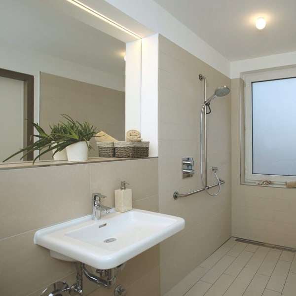 Barrierefreies Bad mit beigen Fließen