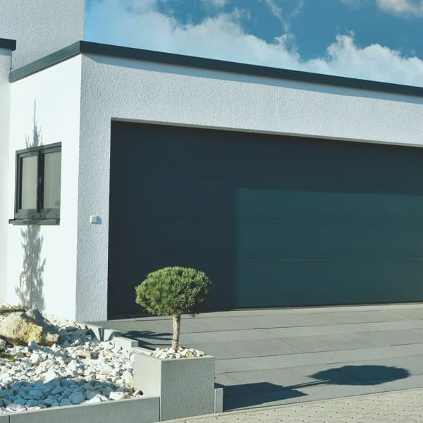 Garage mit breitem Garagentor und Fenster angebaut ans Wohnhaus