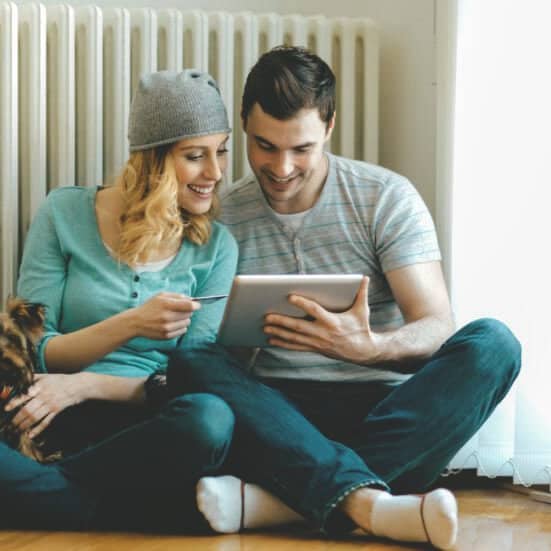 Paar mit Hund sitzen vor neuer Heizung