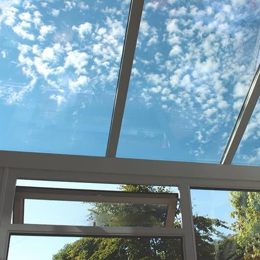 Wintergarten mit Glasdach und freiem Blick auf den Himmel