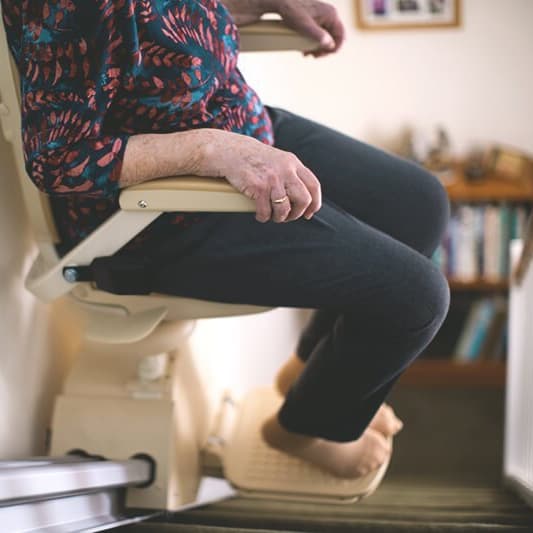 Frau fährt im Sitzlift