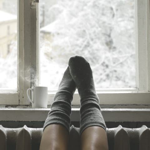 Gemütlicher Wintertag am Fenster mit Ausblick auf verschneite Landschaft