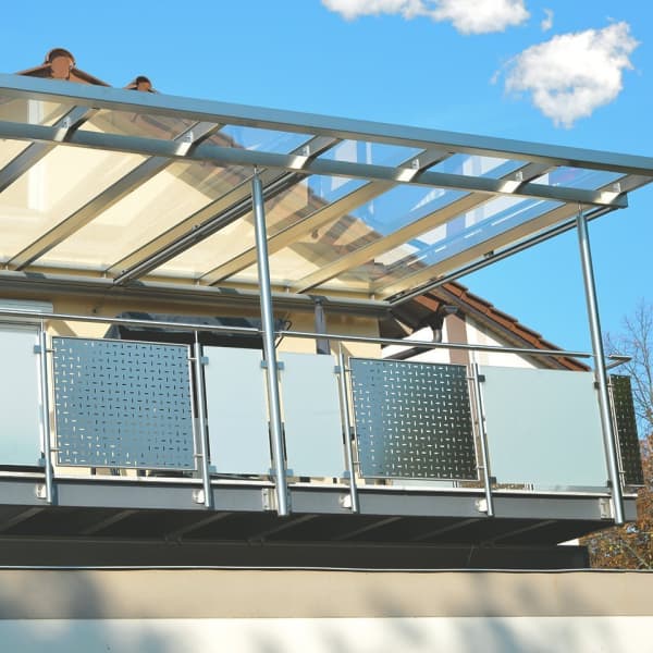 Terrassenüberdachung mit Glasdach an einem Balkon mit Brüstung