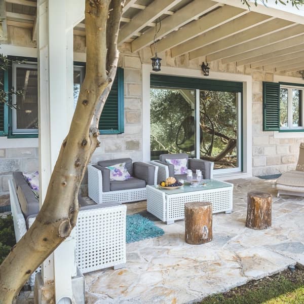 Eine weiß angestrichene Terrassenüberdachung aus Holz mit weißem Marmorboden