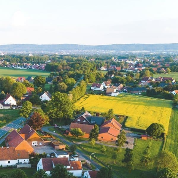 Luftaufnahme einer Ortschaft in Deutschland mit Wiesen bei Sonnenschein
