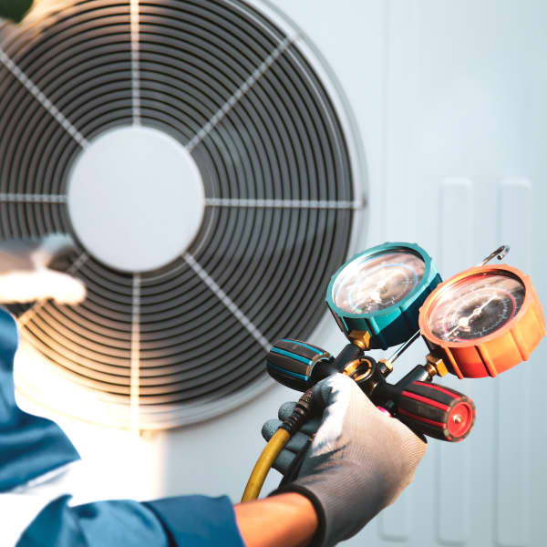 Mechaniker überprüft Kältemittel in einer Wärmepumpe mit einem Manometer