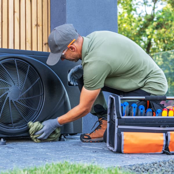 Monteur arbeitet im Freien an einer schwarzen Propan-Wärmepumpe