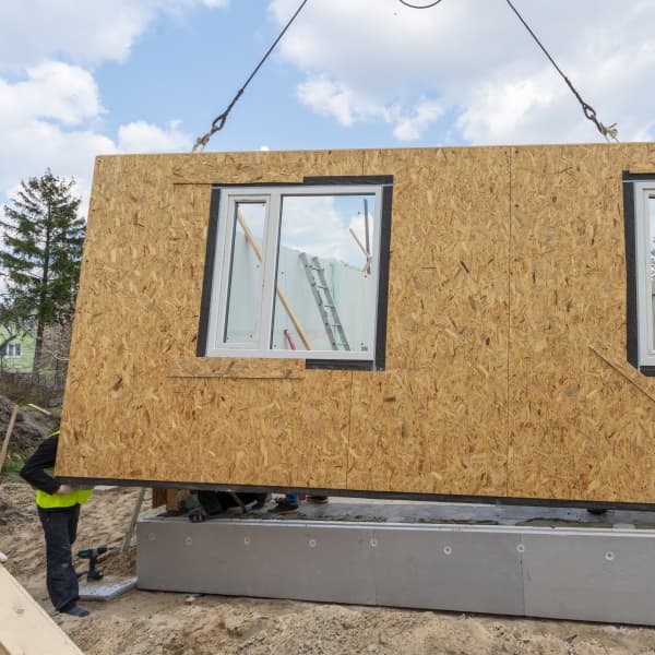 Das Bild zeigt den Aufbau eines Fertighauses mit vorgefertigter Wand