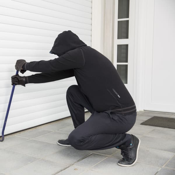 Einbrecher bricht mit einem Stemmeisen in eine Garage ein