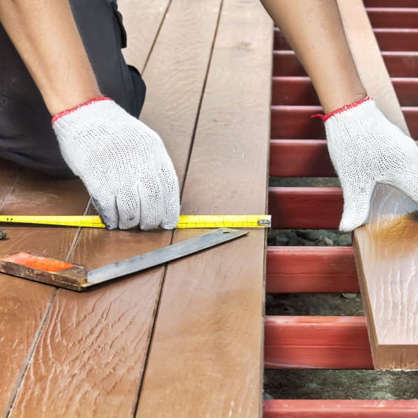 Jemand bringt Holzlatten auf eine Unterkonstruktion an.