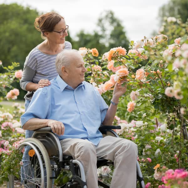 Mann sitzt im Rollstuhl im Garten