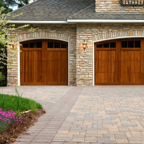 Haus mit Klinkerfassade und gepflasterter Einfahrt.