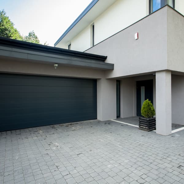 Modernes Einfamilienhaus mit gepflasterter Einfahrt.