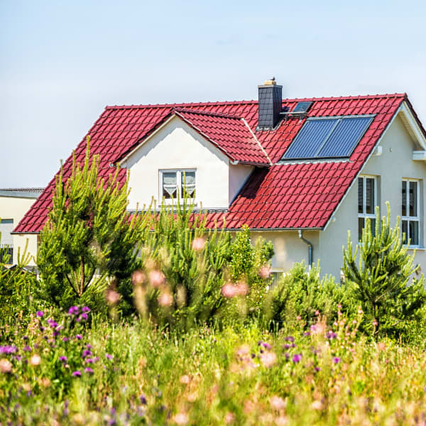 Ansicht auf zwei freistehende Einfamilienhäuser von einer Wiese aus
