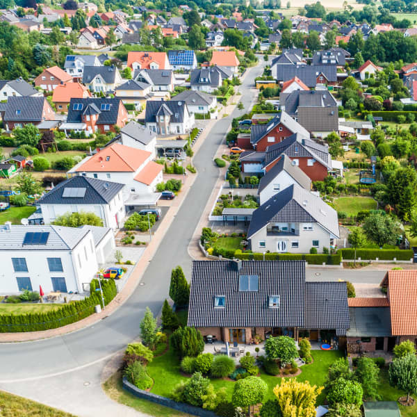 Luftansicht auf ein Neubaugebiet auf dem flachen Land in Norddeutschland zwischen Wald und Feldern und Wiesen